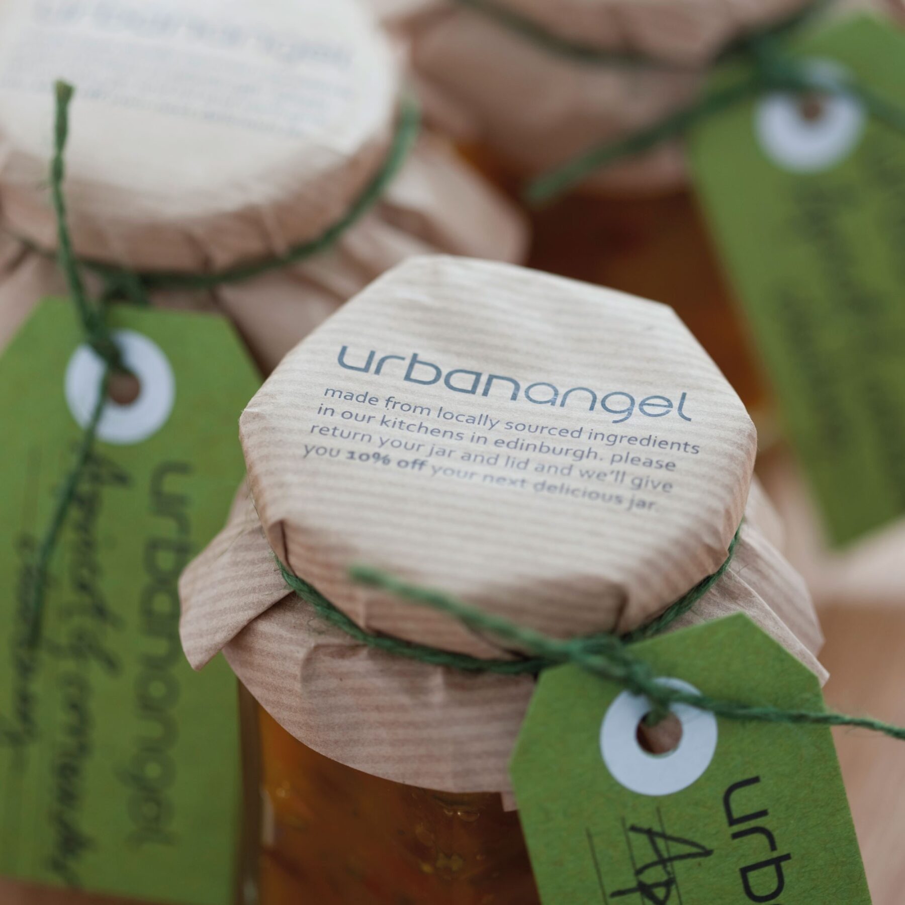 Urbanangel chutney jars with graphics on brown paper lids tied with green twine and packaging labels.