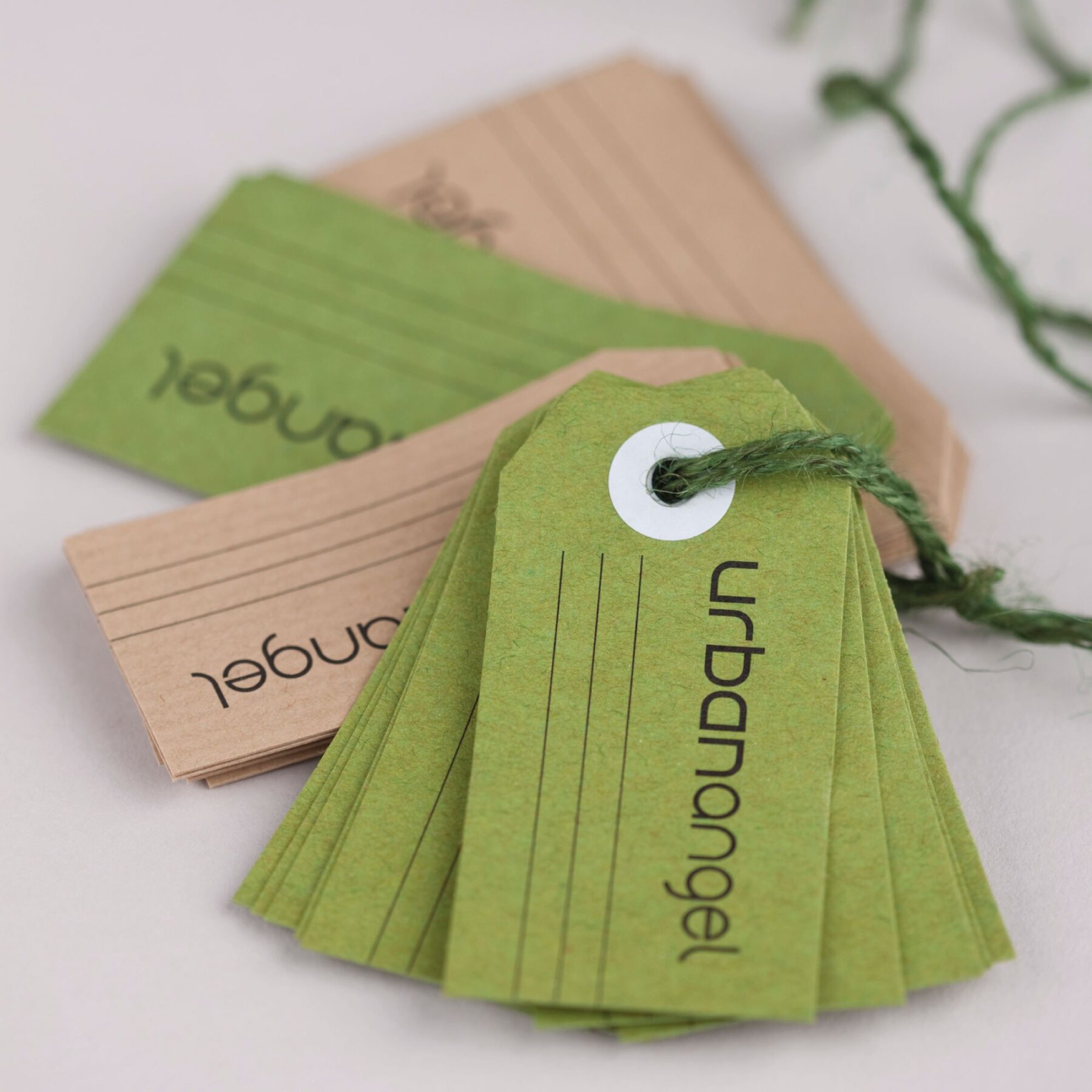 Urbanangel green and kraft paper packaging tags tied with green twine.